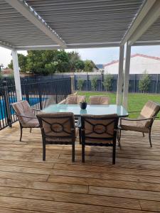 een tafel en stoelen op een houten terras met een patio bij Inner city Sanctuary in Gisborne