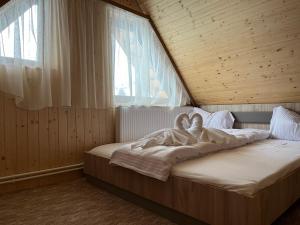ein Schlafzimmer mit einem Bett mit einem Schwan darauf in der Unterkunft Casa Ionuț și Sofia in Podu Dîmboviţei + 13 Fotos