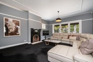 een woonkamer met een bank en een tafel bij Poolside at Kindrogan - St Kilda in Melbourne