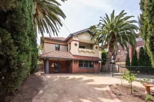 een huis met palmbomen ervoor bij Poolside at Kindrogan - St Kilda in Melbourne