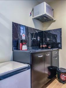 a kitchen with a black counter top and a microwave at Villa de Recriary in Campos do Jordão