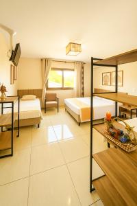 a hotel room with two beds and a table at LSViver Hospedagem in Caxias do Sul