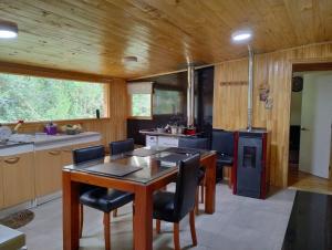 a kitchen with a wooden ceiling and a table and chairs at Hospedaje y Cabañas Ensenada Puerto Varas in Puerto Varas