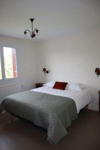 - une chambre dotée d'un grand lit avec des draps blancs et une fenêtre dans l'établissement Maison indépendante-Chambres grand confort, à Monistrol-sur-Loire