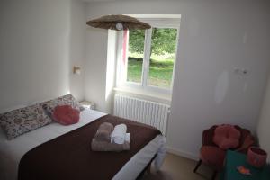 une chambre avec un lit avec des chaussures et une fenêtre dans l'établissement Maison indépendante-Chambres grand confort, à Monistrol-sur-Loire