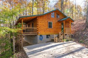 eine Blockhütte im Wald mit einer Terrasse in der Unterkunft Hot Tub & WiFi - Cozy Canopy - Red River Gorge KY in Slade