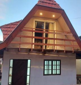 una casa con un balcón encima en Chalé Vila Rica, en Campos do Jordão