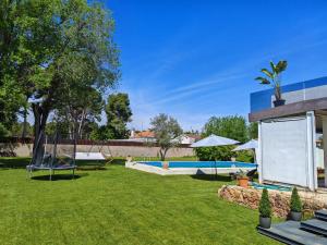 a yard with a pool and a house at Chalet Las Rosas in Albacete