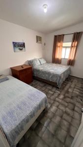 a bedroom with two beds and a dresser in it at Conj Pajuçara 3 minutos da praia, 5 pessoas! in Maceió +57 photos