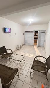 a living room with two chairs and a table at Conj Pajuçara 3 minutos da praia, 5 pessoas! in Maceió