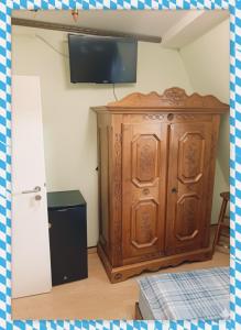 a large wooden cabinet in a room with a tv at Gut & Günstig in Nürnberg