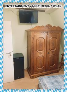 a wooden cabinet in a room with a tv at Gut & Günstig in Nürnberg