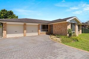 a large brick house with a garage at Bay Breeze Cottage in Callala Bay
