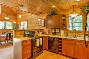eine Küche mit Holzschränken und einem Herd mit Backofen in der Unterkunft Hot Tub & WiFi - ManeStay - Red River Gorge KY in Slade
