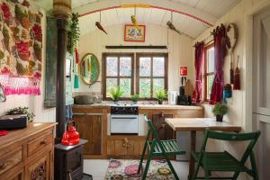 a kitchen with a stove and a table and chairs at Orchard View Shepherds Hut in Henfield