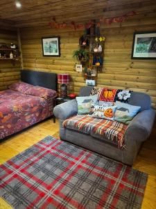 a living room with a couch and a bed at The Miners Log Cabin in Blaina