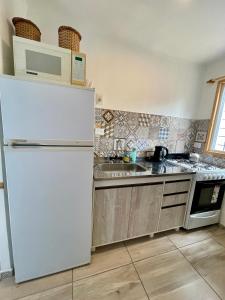 eine Küche mit einem weißen Kühlschrank und einer Spüle in der Unterkunft Casa de Playa Mar de Ajo Castelli 1257 Beach House in Mar de Ajó