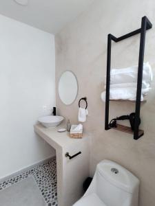 Un baño con inodoro, lavabo y espejo. en Loft Ha, en Chiconcuac