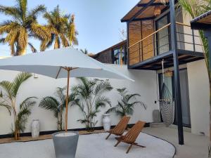 un patio con dos sillas y una sombrilla en Loft Ha, en Chiconcuac