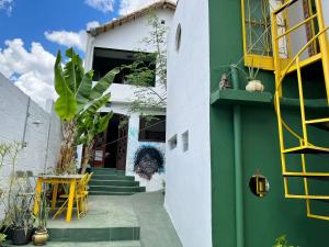 a green and white house with a yellow ladder at HOSTEL Divinópolis in Divinópolis