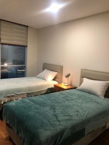 two beds sitting in a room with a window at Spacious, modern brand new apartment 22 best location in La Paz +13 photos