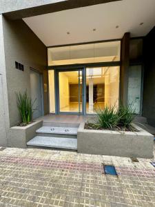 a building with two potted plants in front of it at Temporal en la plata centro in La Plata