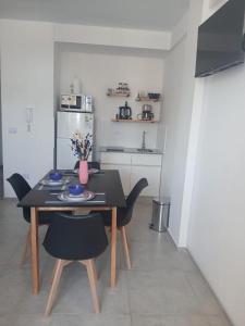 a small kitchen with a table and chairs and a kitchen with a refrigerator at Temporal en la plata centro in La Plata