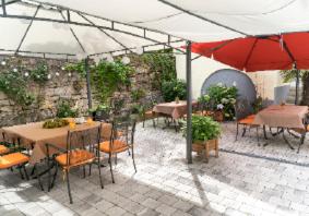 a patio with tables and chairs and an umbrella at Pension Pauserei in Oedheim