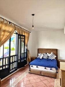 a bedroom with a bed and a large window at Duplex 4 pour les familles in Oualidia