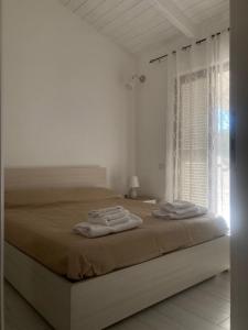 a white bedroom with a bed with towels on it at Rifugio di campagna in Varcaturo +31 photos