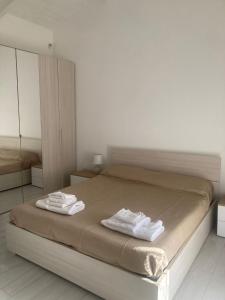 Un dormitorio con una cama con dos toallas encima. en Rifugio di campagna, en Varcaturo