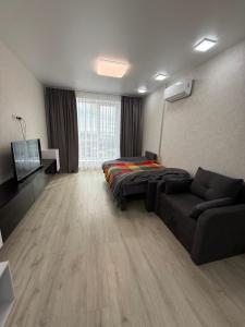 a living room with a couch and a bed and a tv at Квартира с Видом на Море, жк Парус, 9-3 in Chornomorsk