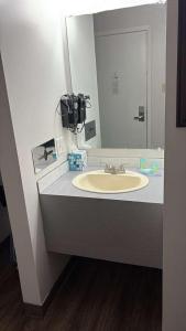 a bathroom with a sink and a large mirror at Heritage Inn in Bellingham