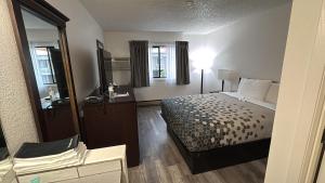 a hotel room with a bed and a mirror at Heritage Inn in Bellingham