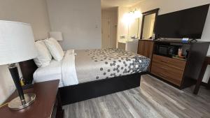 a hotel room with a bed and a flat screen tv at Heritage Inn in Bellingham