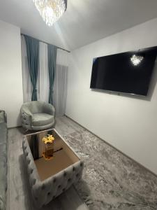 a living room with a couch and a tv on the wall at Apartament Promenada Luxury in Craiova