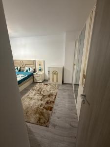 a small bedroom with a bed and a rug at Apartament Promenada Luxury in Craiova