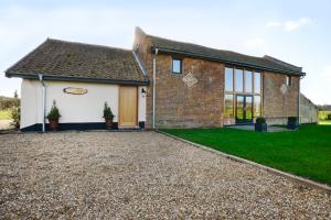 a brick house with a gravel driveway at Old Field Barn Luxury B & B in Attleborough