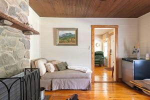 a living room with a couch and a stone wall at Captain's Cabin in Burnsville