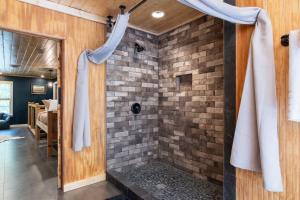 a shower in a room with a brick wall at Captain's Cabin in Burnsville +22 photos