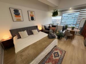 a bedroom with a large bed and a living room at Boho Studio Downtown Rogers Views Heated Parking in Edmonton