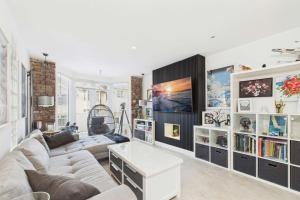 ein Wohnzimmer mit Sofa und Fernseher in der Unterkunft Modern 2 Bedroom Family Home in Torquay - Sleeps 4 in Torquay