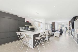 eine Küche mit einer weißen Theke und einigen Stühlen in der Unterkunft Modern 2 Bedroom Family Home in Torquay - Sleeps 4 in Torquay