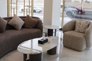 a living room with a couch and two tables at فندق جراند جرين in Jazan