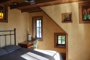 een slaapkamer met een bed en een trap met ramen bij Anam Cara Cabin in Mohawk