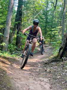 een persoon die fietst op een pad in het bos bij Anam Cara Cabin in Mohawk