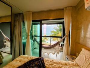 a bedroom with a hammock and a large window at Kauai Beach Residence 403 in Tamandaré +68 photos