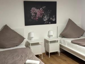 een slaapkamer met 2 bedden en 2 tafels met lampen bij Casaba Suite 2-150qm-4 Rooms-Free Private Parking-House with garden in Hannover