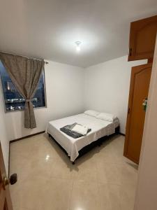 a bedroom with a bed and a window at Torrecoral704 in Estación El Salto