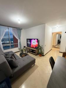 a living room with a couch and a flat screen tv at Torrecoral704 in Estación El Salto